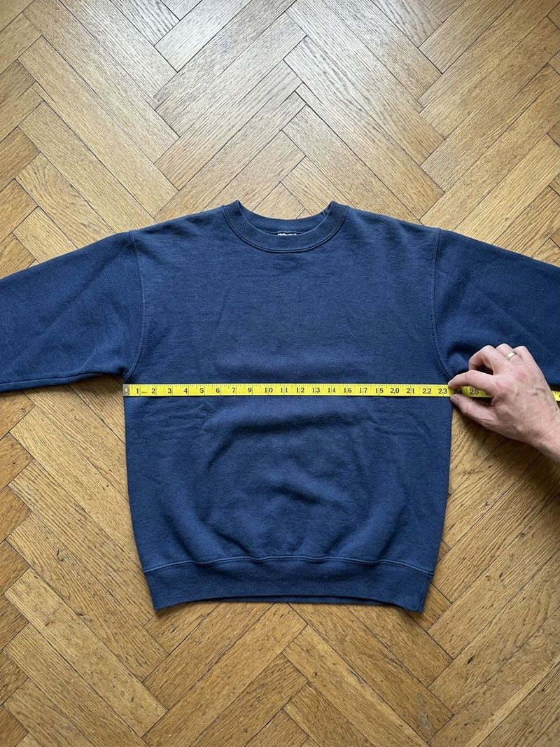Sweat posé à plat, mètre ruban tendu d'aisselle à aisselle
